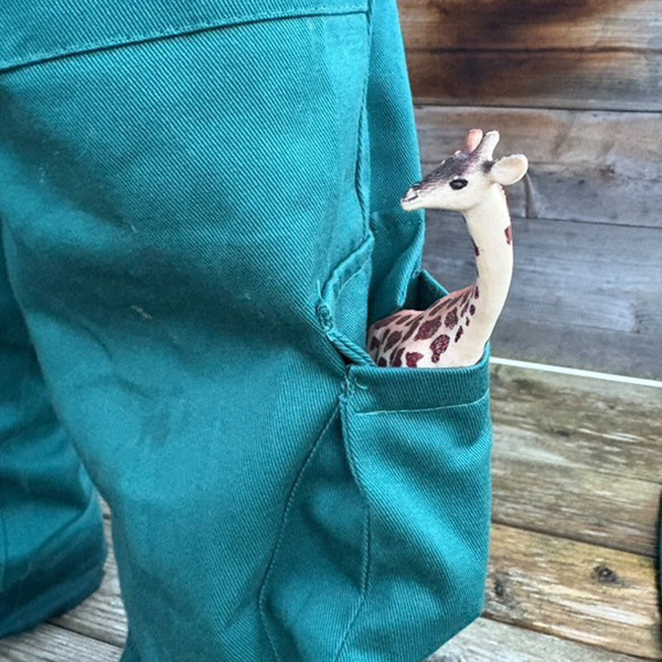a young firefighter in his uniform looking at a red fire engine.